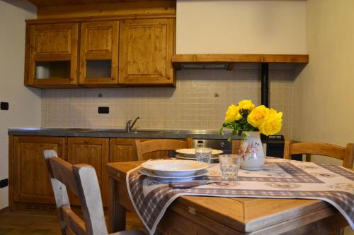a kitchen with a wooden table with yellow flowers on it at Lo Coppa Fen in Aosta