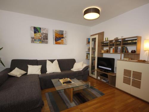 uma sala de estar com um sofá e uma televisão em Apartment Tivoli by Interhome em Innsbruck