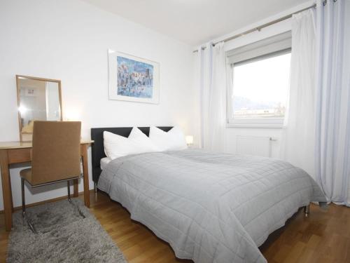 Schlafzimmer mit einem Bett, einem Schreibtisch und einem Fenster in der Unterkunft Apartment Tivoli by Interhome in Innsbruck