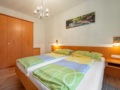 a bedroom with a large bed and a chandelier at Apartment Kleinsee by Interhome in Srejach