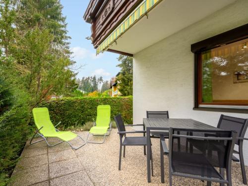 a patio with a black table and green chairs at Apartment Georgiberg by Interhome in Srejach