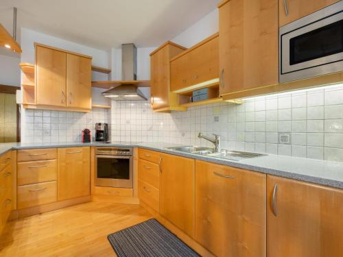 a kitchen with wooden cabinets and a sink at Apartment Georgiberg by Interhome in Srejach