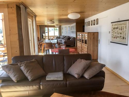 a living room with a brown couch and a table at Apartment Gloria by Interhome in Mürren