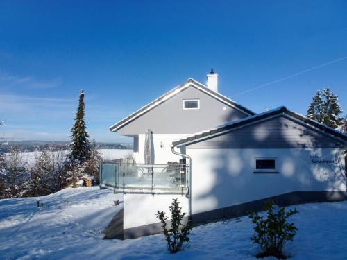 a white house with snow on the ground at Holiday Home Schwarzwald by Interhome in Dittishausen