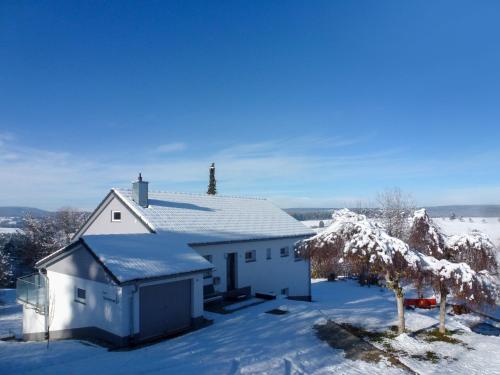 a white house with snow on the roof at Holiday Home Schwarzwald by Interhome in Dittishausen