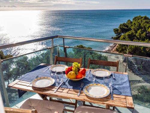 een tafel met een fruitschaal op een balkon met uitzicht op de oceaan bij Apartment Gala I-2 by Interhome in Miami Platja