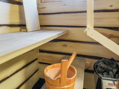 a sauna with wooden walls and a bucket at Holiday Home Huitsin nevada by Interhome in Kangosjärvi