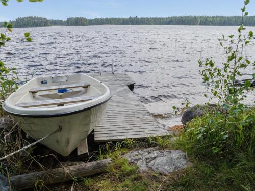 un barco sentado en un muelle junto a un lago en Holiday Home Ulpukka by Interhome, en Savilahti