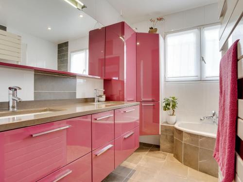 - une cuisine rouge avec un évier et une baignoire dans l'établissement Holiday Home Baschoc by Interhome, à Mimizan