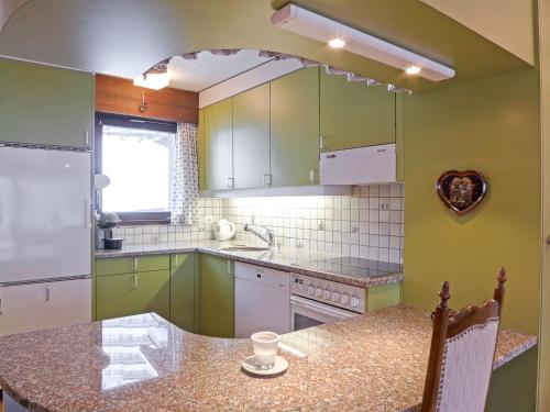 a kitchen with green cabinets and a counter top at Apartment Rustica Apt- M by Interhome in Wengen