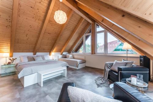 a attic bedroom with two beds and a couch at Luxury apartman Lipno in Lipno nad Vltavou