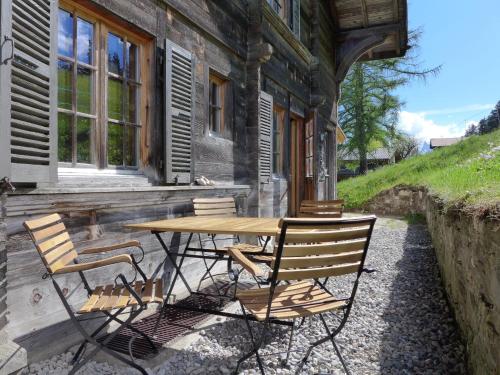 a wooden table and chairs outside of a house at Apartment Chalet Ahorni by Interhome in Hornkessel