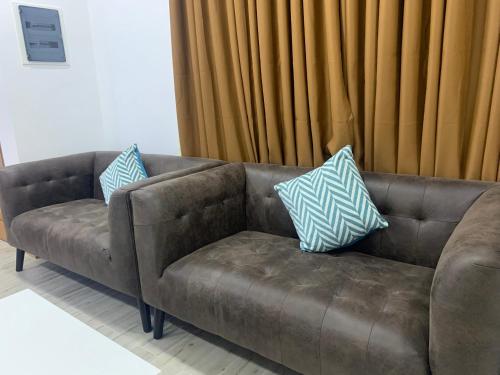 a brown couch with two blue and white pillows on it at Sky View by Relax Tours in Dhangethi