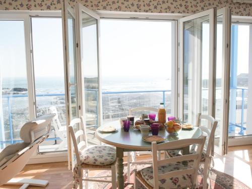 une salle à manger avec une table, des chaises et des fenêtres dans l'établissement Apartment Hoédic by Interhome, à Quiberon