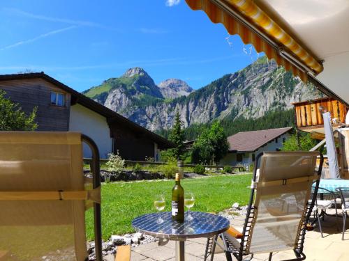 une table et des chaises sur une terrasse avec des montagnes en arrière-plan dans l'établissement Apartment Laerchehus Ost by Interhome, à Kandersteg