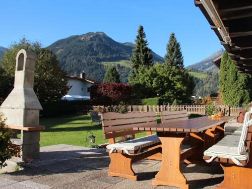 a wooden picnic bench with a view of a mountain at Holiday Home Sonnblick by Interhome in Uderns