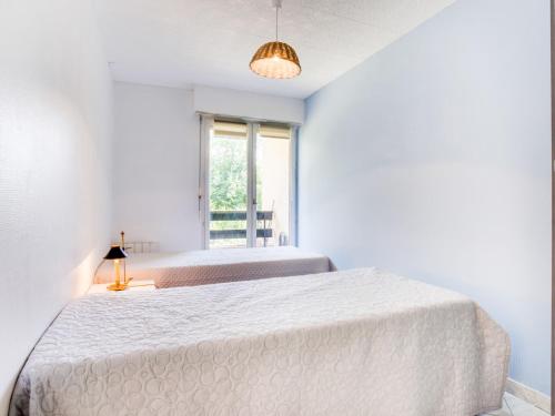 une chambre blanche avec un grand lit et une fenêtre dans l'établissement Apartment Le Sporting-15 by Interhome, à Cabourg