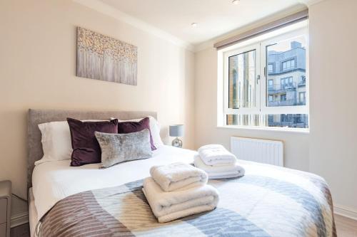 sypialnia z łóżkiem z ręcznikami w obiekcie Stunning 3-bedroom in the heart of London with parking-hosted by Sweetstay w Londynie