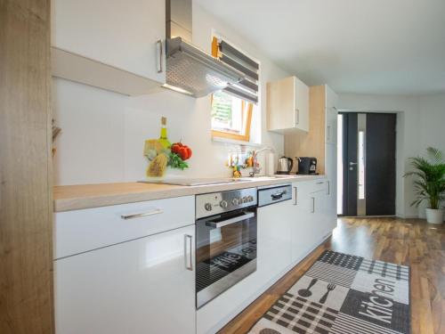 een keuken met witte kasten en een fornuis met oven bij Apartment Mundlers Hoamatl-3 by Interhome in Oetz