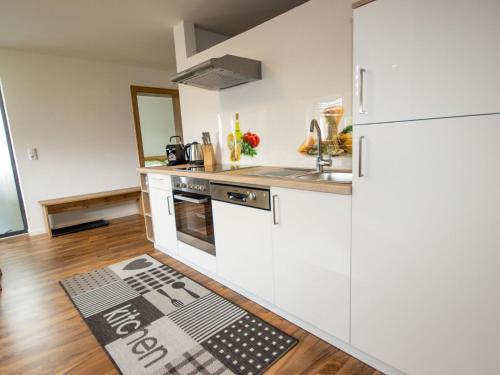 オエッツにあるApartment Mundlers Hoamatl Top 2 by Interhomeの白いキャビネットとキッチンラグ付きのキッチン(床)