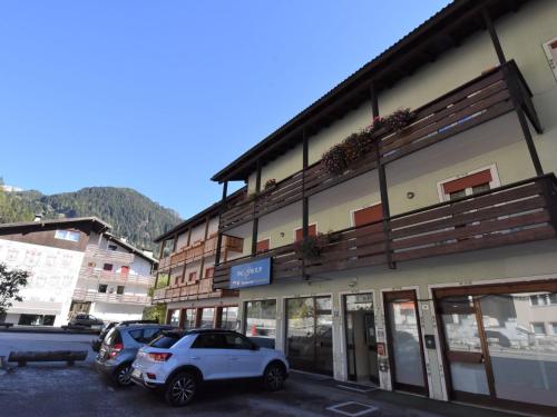a building with cars parked in a parking lot at Apartment Cesa Lucilla by Interhome in Canazei