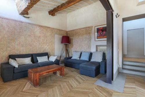 a living room with a couch and a table at Belle Arti Penthouse-hosted by Sweetstay in Florence