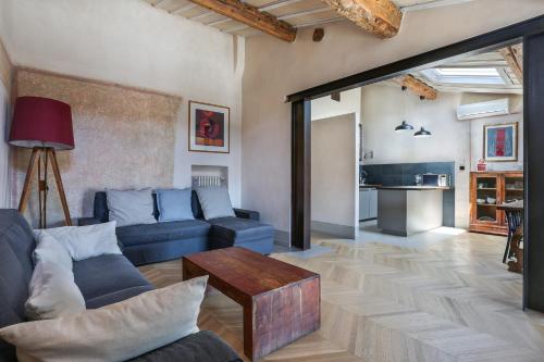 een woonkamer met een blauwe bank en een tafel bij Belle Arti Penthouse-hosted by Sweetstay in Florence