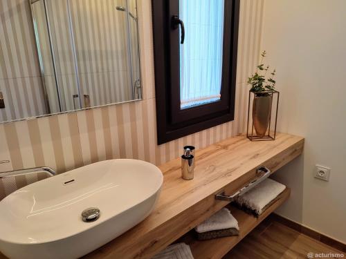La salle de bains est pourvue d'un lavabo blanc et d'un miroir. dans l'établissement Aires De Míguez, à Jove
