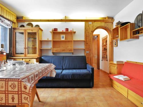 een woonkamer met een blauwe bank en een tafel bij Apartment Des Alpes-8 by Interhome in Canazei