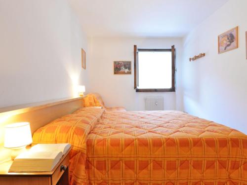 a bedroom with a bed and a table with a lamp at Apartment Condominio al Parco-2 by Interhome in Canazei