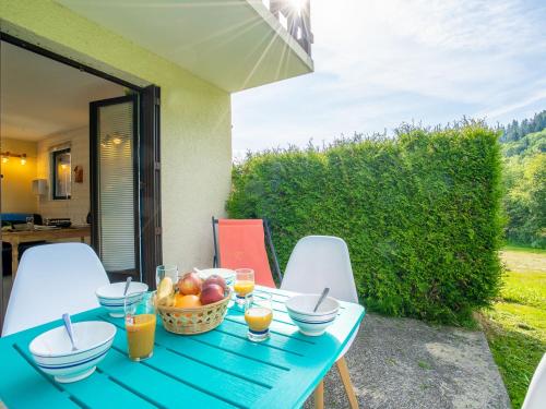 a blue table with a basket of fruit on a patio at Apartment Le Bochate-8 by Interhome in Saint-Pancrace