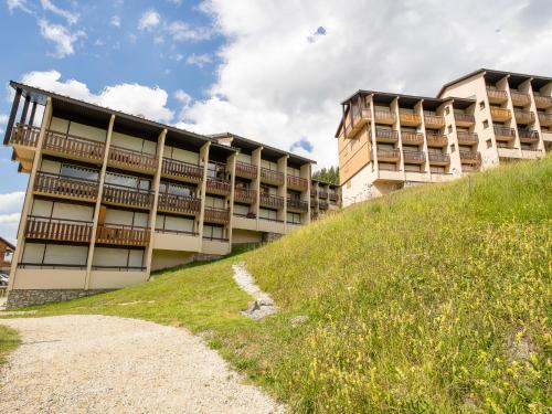 un immeuble d'appartements sur une colline avec une colline herbeuse dans l'établissement Apartment Asters 322 Bâtiment A1 by Interhome, aux Menuires