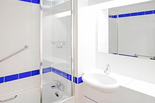 biała łazienka z umywalką i prysznicem w obiekcie Warrington Motel, J20 M6 Lymm Services w mieście Warrington