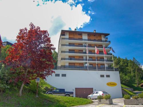 Ein großes weißes Gebäude mit zwei amerikanischen Flaggen darauf in der Unterkunft Apartment Chaedoz 36 by Interhome in Nendaz