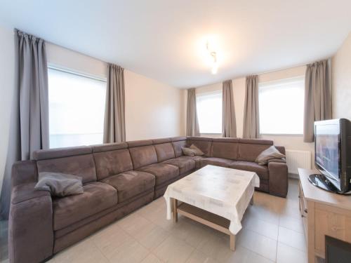 ein Wohnzimmer mit einem braunen Sofa und einem Couchtisch in der Unterkunft Holiday Home Boonenhove-3 by Interhome in De Haan