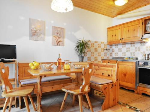 a kitchen with a wooden table and chairs at Studio Marmolada-5 by Interhome in Alba di Canazei