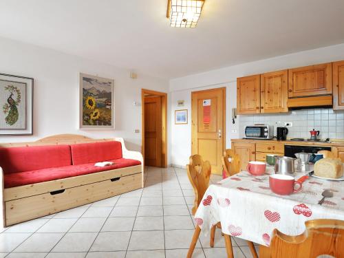 a living room with a red couch and a table at Apartment Villa Placidia Apt 22 by Interhome in Campitello di Fassa