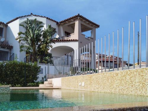 una casa con piscina di fronte a un edificio di Apartment Panorama 7 by Interhome a Budoni