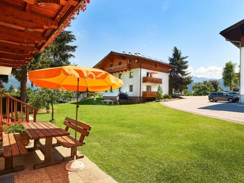 a picnic table with an umbrella in a yard at Apartment Sonnberg-3 by Interhome in Flachau