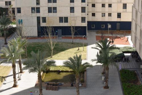 an overhead view of a building with palm trees at דירות גני תערוכה - TLV university apartments near Expo by Sea N' Rent in Tel Aviv