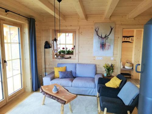 uma sala de estar com um sofá azul e uma mesa em Chalet Buchfink by Interhome em Hochrindl