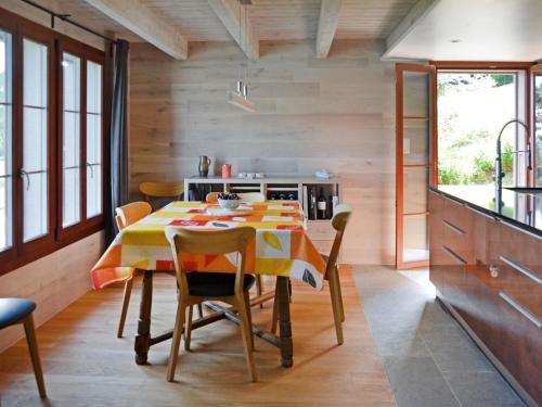 a kitchen with a dining room table with chairs at Chalet Chalet la Frêtaz by Interhome in Bullet