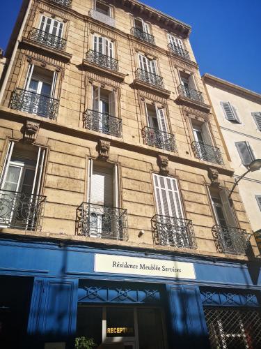 un grand bâtiment avec des balcons sur le côté dans l'établissement Résidence Meublée Services, à Marseille