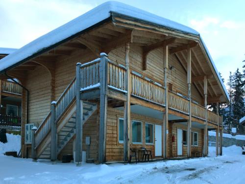 a log cabin with a deck in the snow at Apartment Sur Baselgia by Interhome in Cunter