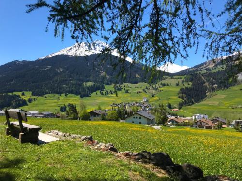 a bench in a field with a mountain in the background at Apartment Sur Baselgia by Interhome in Cunter