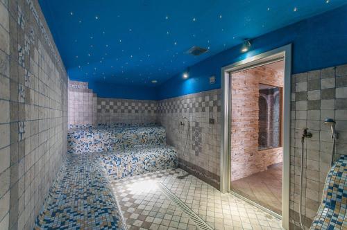 baño con paredes azules y techos azules en Alpholiday Dolomiti Wellness & Family Hotel, en Dimaro