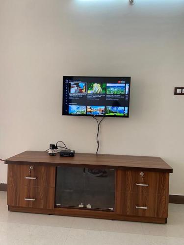 a flat screen tv on top of a wooden entertainment center at Dona Rosa Holiday Apartment in Varca