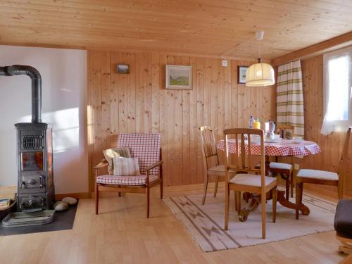 ein Wohnzimmer mit einem Tisch und einem Holzofen in der Unterkunft Holiday Home Chalet Esther by Interhome in Brienz