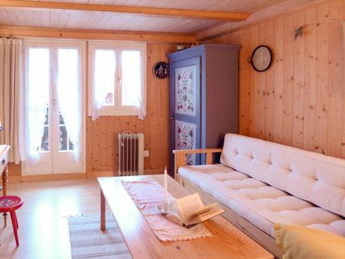 ein Wohnzimmer mit einem Sofa und einem Tisch in der Unterkunft Holiday Home Chalet Esther by Interhome in Brienz