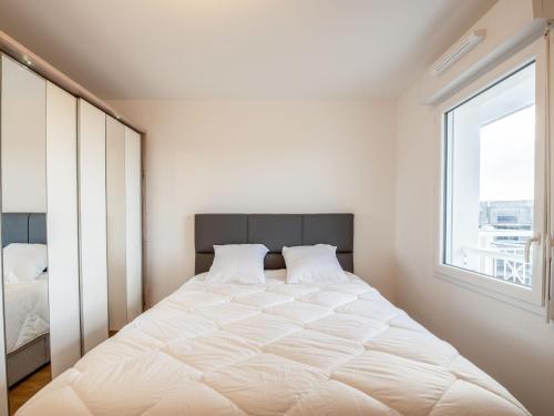 een slaapkamer met een groot wit bed en een raam bij Apartment Les Cavaliers by Interhome in Cabourg